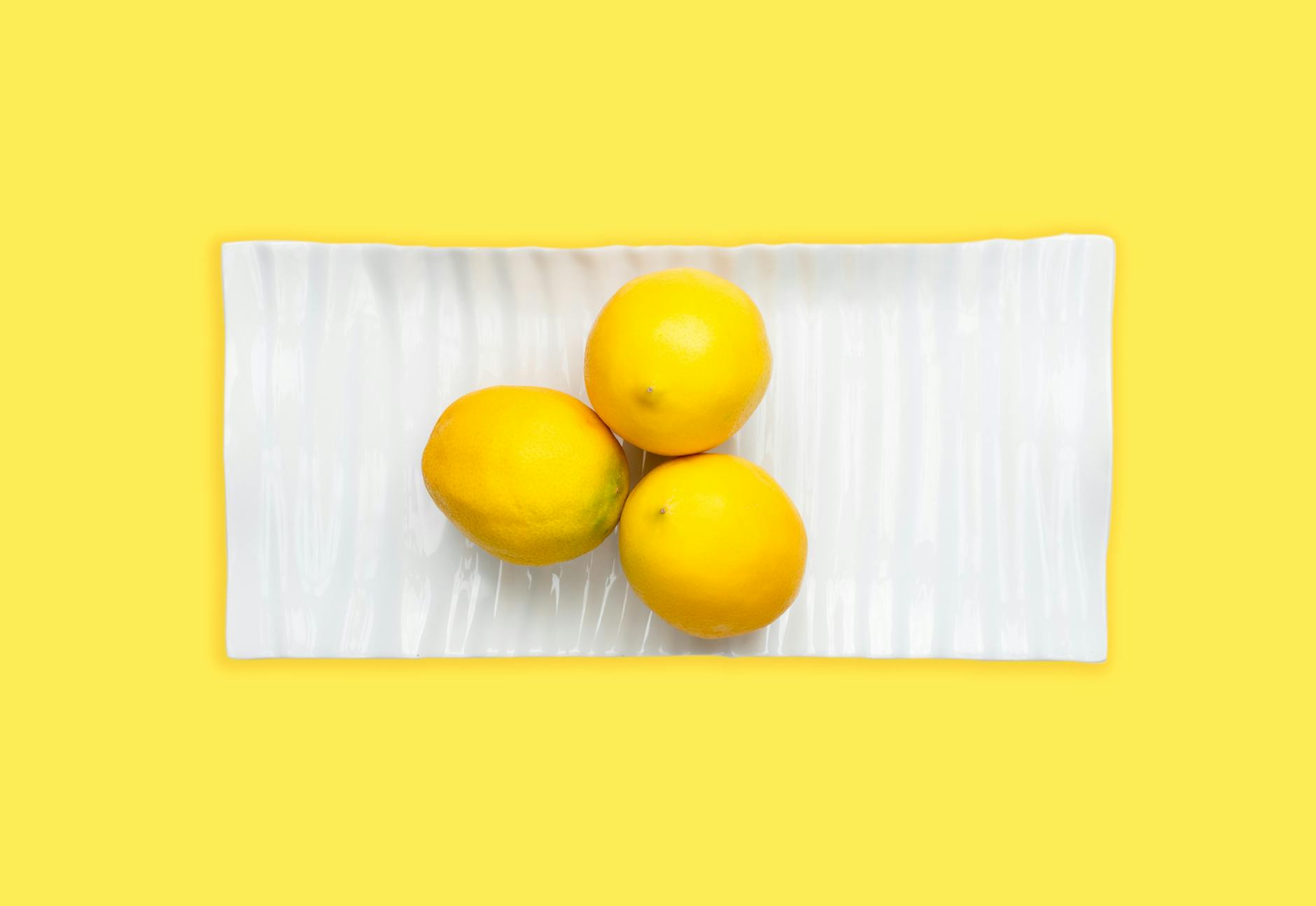 Fresh lemons on a green background, symbolizing how sensation and pleasure evolve naturally over time