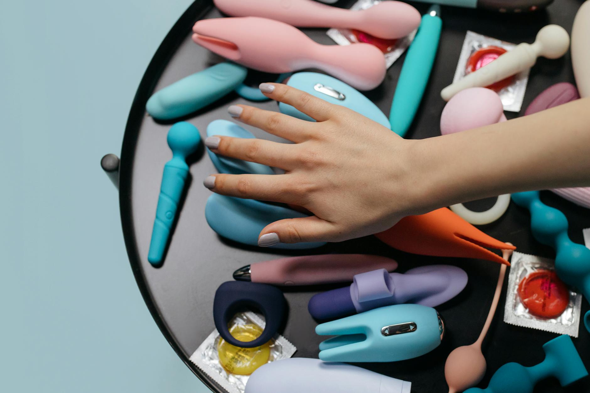 A hand holding a modern vibrator against a minimalist purple backdrop, representing control and gentle sensation